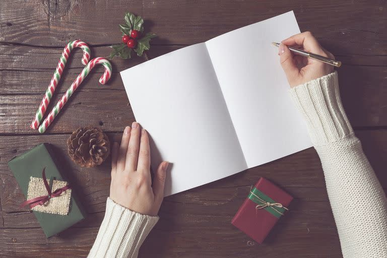 woman writing in blank christmas card