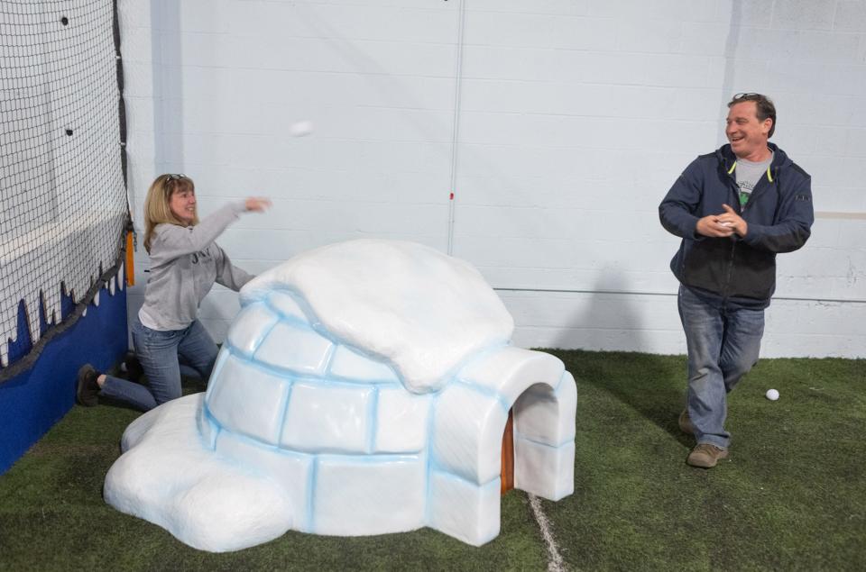 Kim Shapiro and John Eslich play around and throw pretend snowballs at the new Ohio Christmas Factory holiday attraction at the Factory of Terror in Canton. The family-friend attraction opens Saturday.