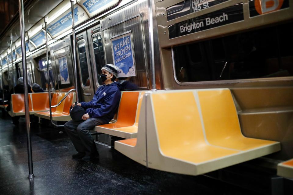 A commuter wears a face mask while riding a nearly empty subway car into Brooklyn on March 12.