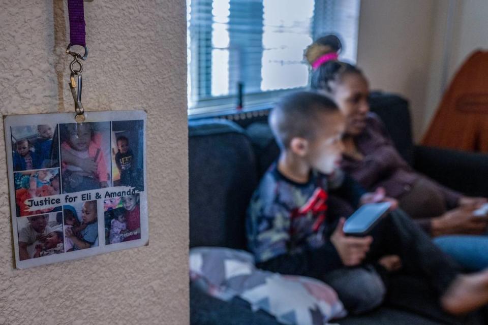 Marquisha Brown and her son Elijah rest on a couch in their living room in April. A lanyard hangs near their front door with pictures of her daughter Amanda Marie Owens, who died in 2021 after she and her brother were allegedly beaten by Brown’s former boyfriend Derrick Dimone Woods. Brown said she wears the lanyard to the court hearings for Woods, who faces murder and other charges in the case.