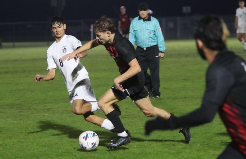 New Smyrna Beach High's Weston Desoto (7) works down field as Spruce Creek High's Sebastian Naranjo (8) races to block, Thursday, January 18, 2024 during the Five Star Conference boys soccer final.