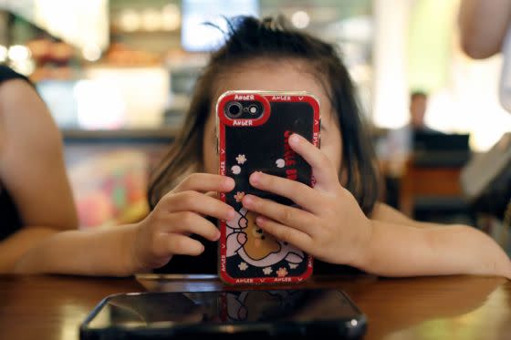 A girl uses a smartphone in Vietnam in June 2022.<span class="copyright">Godong/Universal Images Group/Getty Images</span>