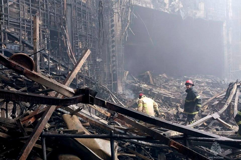 2024年3月23日，俄羅斯莫斯科郊區克洛庫斯音樂廳（Crocus City Hall）遭恐攻的隔天，消防員在音樂廳燒毀的部分查看狀況。美聯社