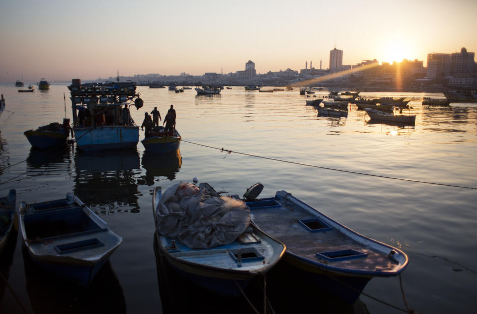 FILE - In this April 3, 2019, file photo, Palestinian fishermen arrive on their boats to the Gaza seaport, after a night fishing trip. The Israeli military says it’s scaling back the permitted fishing zone off the Mediterranean coast of Gaza following a rocket attack from the strip the previous day. The military said Tuesday, April 30, 2019 that fishing would only be permitted up to 6 nautical miles — about 11 kilometers — until further notice. (AP Photo/Khalil Hamra, File)