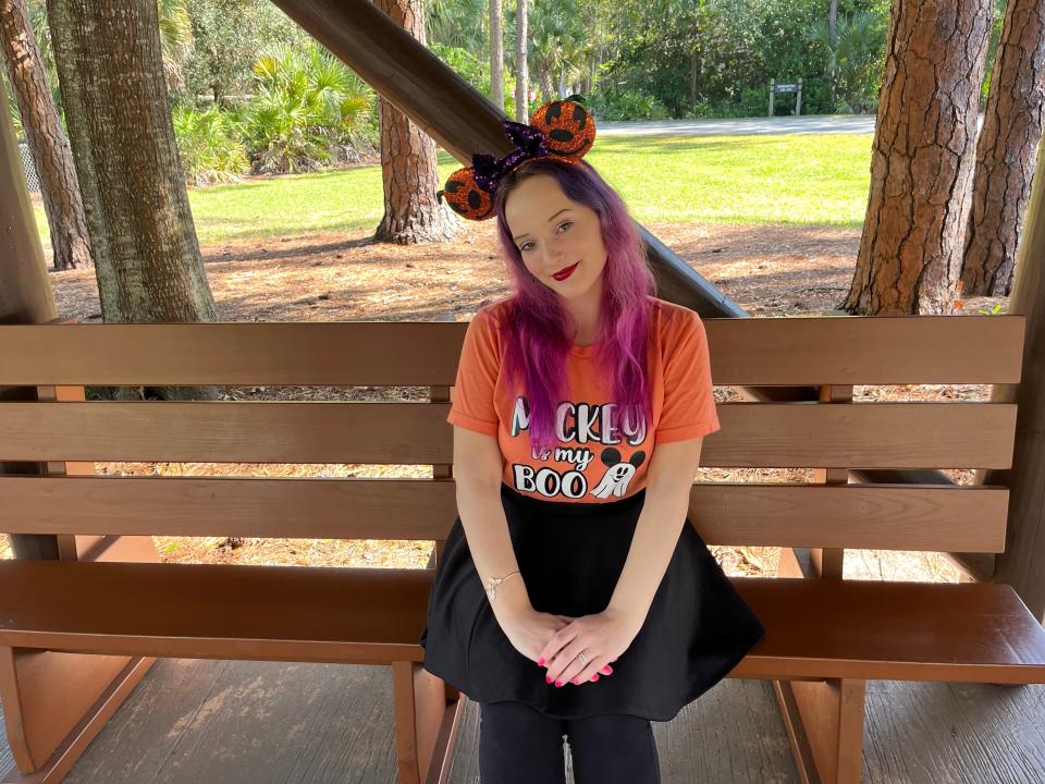 The writer sitting on a bench at the bus stop in disney world