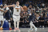 Dallas Mavericks guard Kyrie Irving, right, forces the ball loose for a turnover against Denver Nuggets center Nikola Jokic (15) during the first half of an NBA basketball game in Dallas, Sunday, March 17, 2024. (AP Photo/LM Otero)
