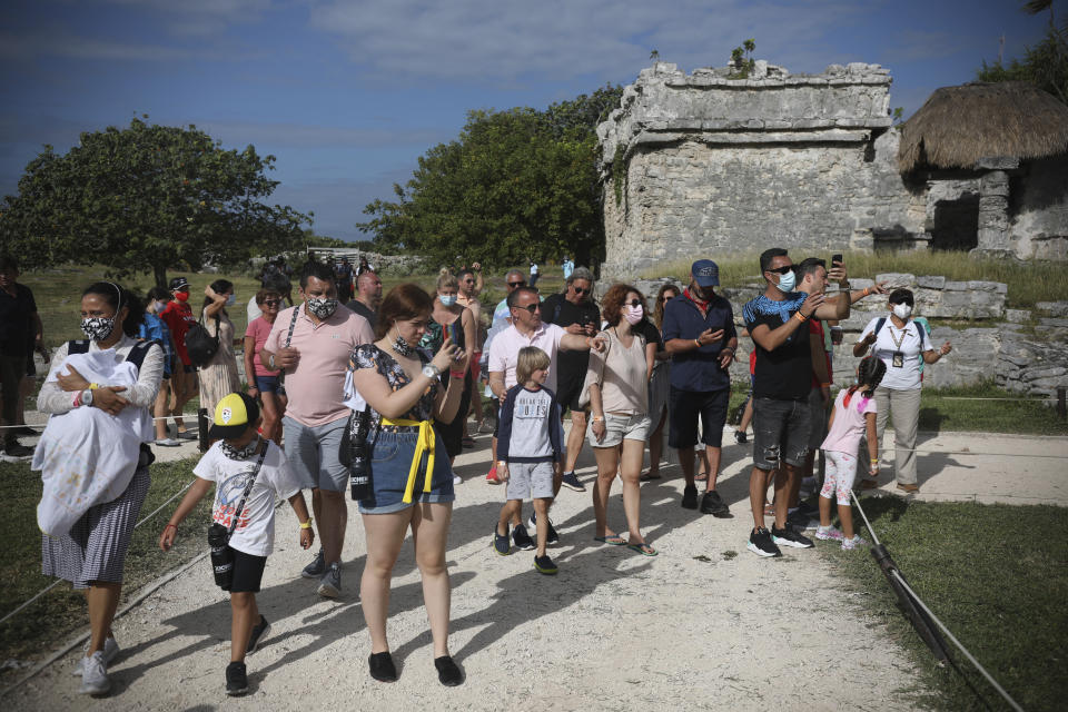 Tourists, required to wear protective face masks amid the new coronavirus pandemic, visit the Mayan ruins of Tulum in Quintana Roo state, Mexico, Tuesday, Jan. 5, 2021. More U.S. tourists came to Quintana Roo during this pandemic-stricken holiday season than did a year earlier when the world was just beginning to learn of COVID-19. They account for 9 out of 10 foreign tourists, said state Tourism Secretary Marisol Vanegas. (AP Photo/Emilio Espejel)
