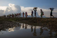 <p>Thousands of Rohingya refugees fleeing from Myanmar walk along a muddy rice field after crossing the border in Palang Khali, Cox’s Bazar, Bangladesh, on October 9, 2017. (Photograph by Paula Bronstein/Getty Images) </p>