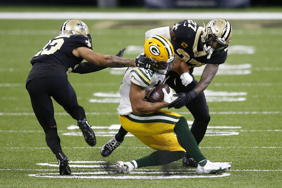 Green Bay Packers wide receiver Allen Lazard (13) is tackled by New Orleans Saints strong safety Malcolm Jenkins (27) and cornerback Marshon Lattimore in the second half of an NFL football game in New Orleans, Sunday, Sept. 27, 2020. (AP Photo/Butch Dill)