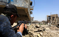 <p>A member of Iraqi federal police force takes position in front of an Islamic State militants’ position during a battle at Dawasa district in the center of western Mosul city, Iraq, May 24, 2017. The Iraqi forces will launch a new operation to retake the old city area which still under IS control, in the center of the western side of Mosul, after surrounding the area from all sides. Thousands of people flee the city every day towards refugee camps due to the fighting. (Photo: Ahmed Jalil/EPA) </p>