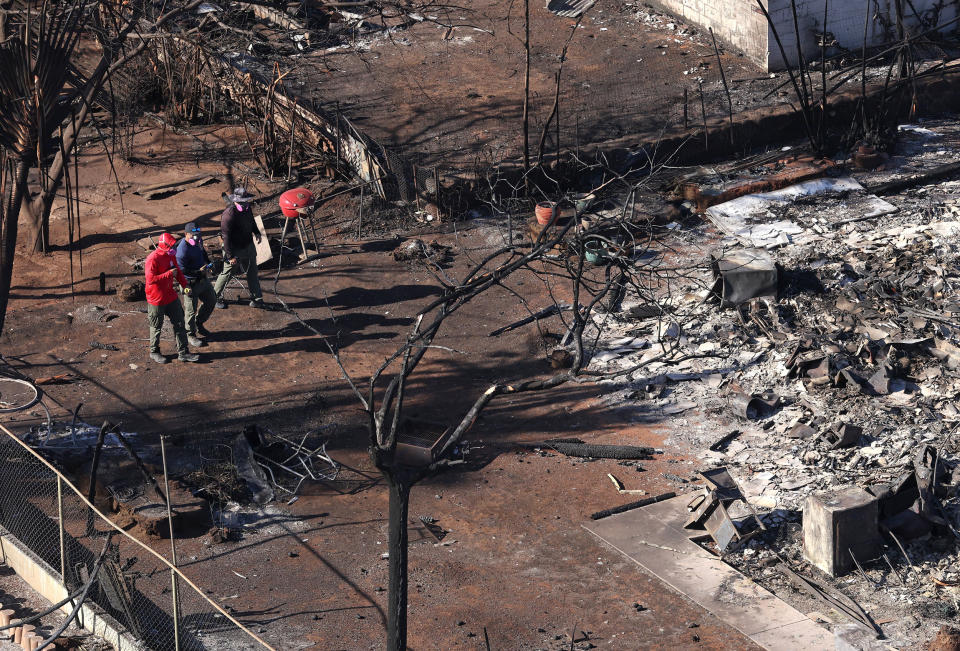 Search and rescue crews walk through a destroyed neighborhood on Aug. 11, 2023 in Lahaina, Hawaii.  (Justin Sullivan / Getty Images)