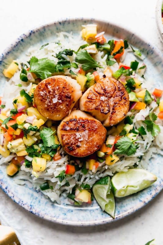 <p>Plays Well With Butter</p><p>Island-style seared scallops with mango salsa and coconut rice are the perfect way to add a little bit of bright, tropical flair to your life any night of the week!</p><p><strong>Get the recipe: <a href="https://playswellwithbutter.com/scallops-with-mango-salsa/" rel="nofollow noopener" target="_blank" data-ylk="slk:Scallops with Mango Salsa;elm:context_link;itc:0;sec:content-canvas" class="link ">Scallops with Mango Salsa</a></strong></p>