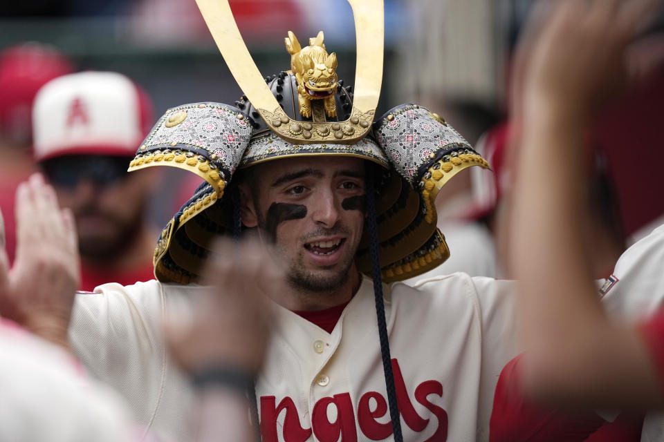 Los Angeles Angels' Zach Neto is congratulated by teammates in the dugout after hitting a solo home run as he wears a Kabuto during the second inning of a baseball game against the Seattle Mariners Sunday, June 11, 2023, in Anaheim, Calif. (AP Photo/Mark J. Terrill)