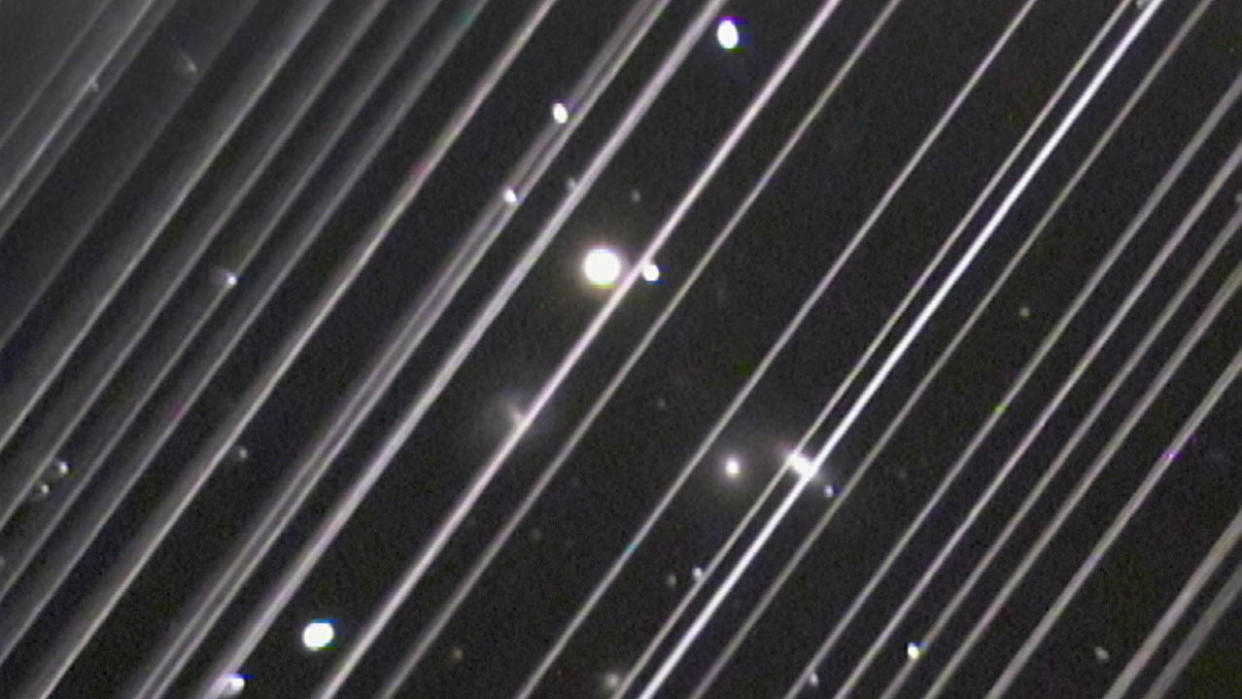  The image shows diagonal lines caused by the light reflected by a group of 25 Starlink satellites passing through the field of view of a telescope at Lowell Observatory in Arizona during observations of the NGC 5353/4 galaxy group on May 25, 2019. 