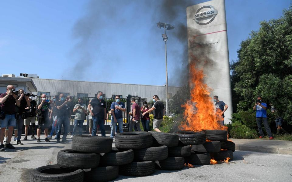 Nissan workers burn tyres in front of the Barcelona factory after the decision to end production in Spain