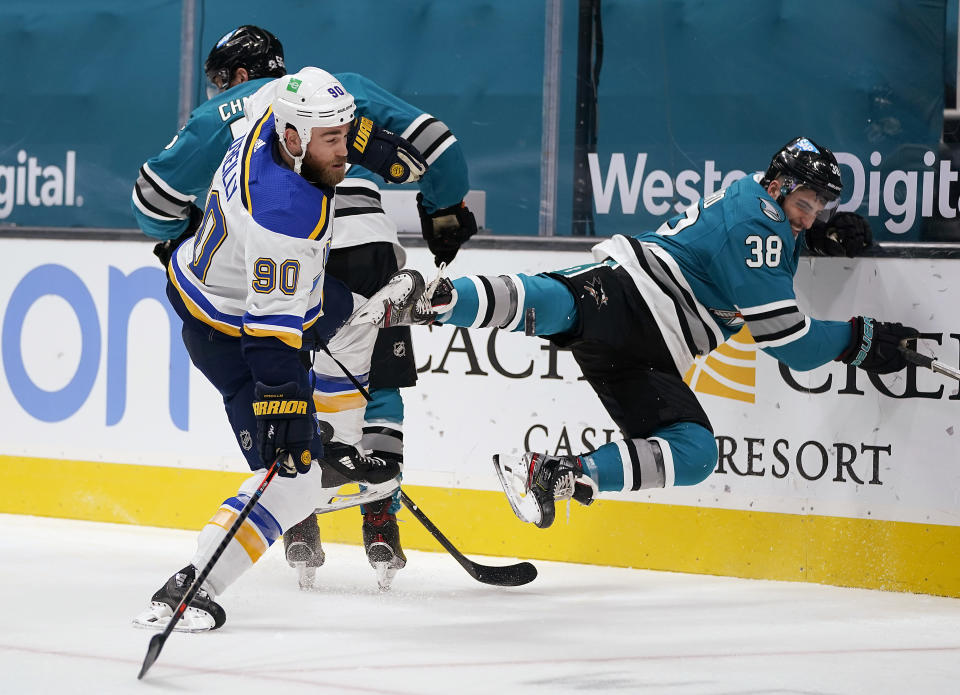 San Jose Sharks defenseman Mario Ferraro (38) is checked into the boards by St. Louis Blues center Ryan O'Reilly (90) during the second period of an NHL hockey game in San Jose, Calif., Saturday, Feb, 27, 2021. (AP Photo/Tony Avelar)