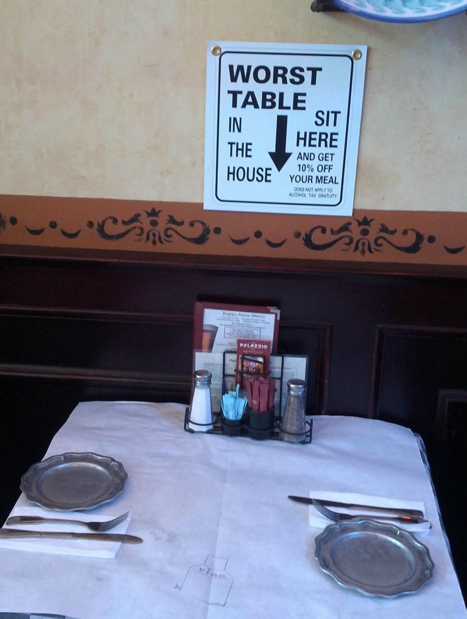 sign above a table says it's the worst table in the house