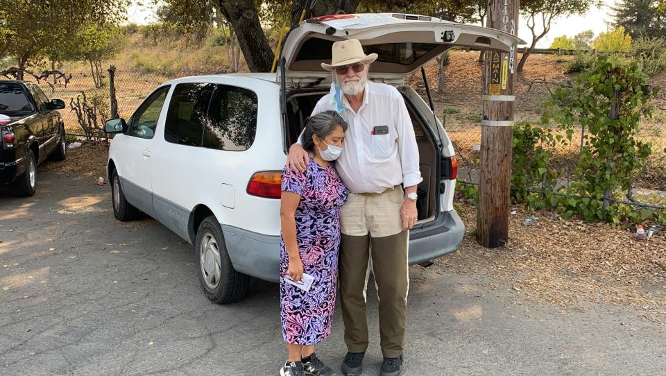 Wildfire evacuees Mike Christianson and his wife Mluz Torres stand in front their minivan outside a church shelter in Napa, Calif. on Tuesday, Sept. 29, 2020. They learned Monday their house in Deer Park in Napa Valley burned down. (AP Photo/Terry Chea)