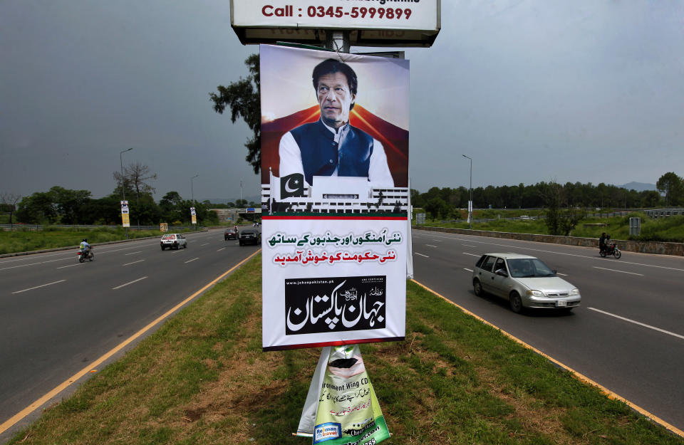 A poster with images of Imran Khan is displayed in the celebration of his government at a highway in Islamabad, Pakistan, Saturday, Aug. 18, 2018. Pakistan's cricket star-turned-politician Khan was sworn in as prime minister on Saturday despite protests by opposition parties, which accuse the security services of intervening on his behalf in last month's elections. The poster reads 'Welcome to this new government with new hopes and aspiration'. (AP Photo/Anjum Naveed)