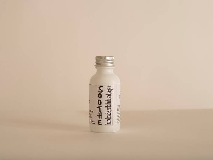 A labeled white bottle stands against a neutral backdrop