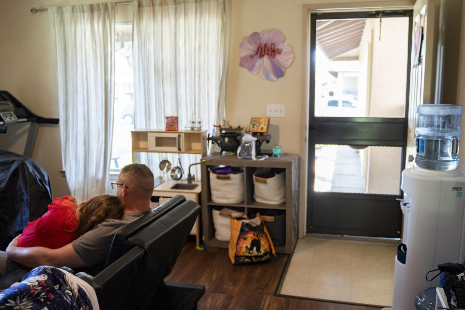 Richelle Dietz's husband holds their daughter, Victoria, at their home in Joint Base Pearl Harbor-Hickam, Monday, April 22, 2024, in Honolulu, Hawaii. The Dietz family has been impacted by the tainted water from the jet fuel leak in 2021. (AP Photo/Mengshin Lin)