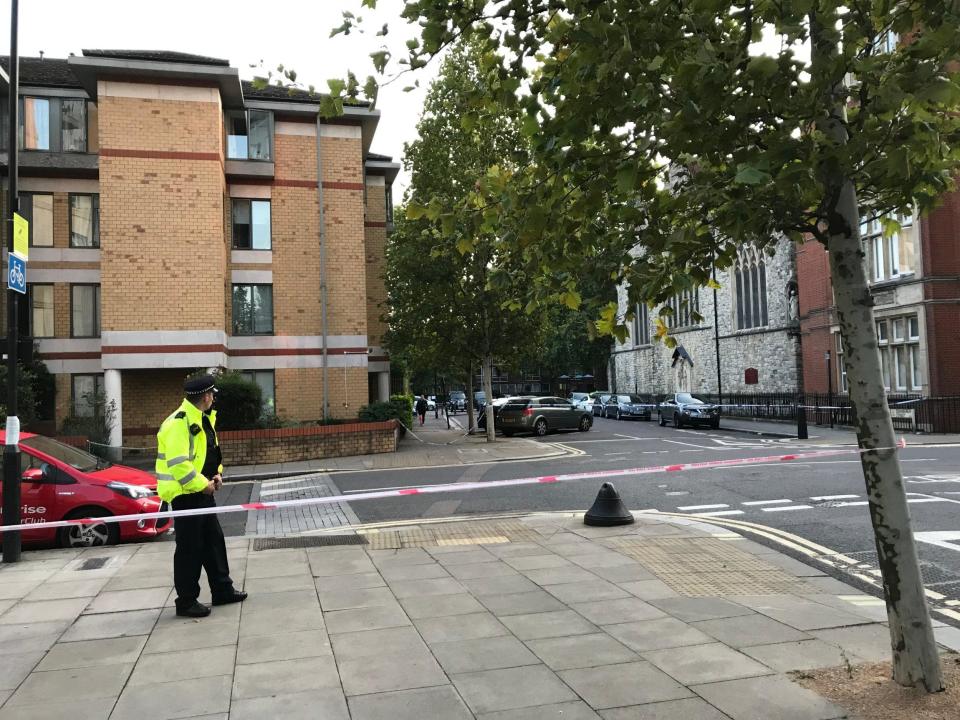 Police officers stand at the cordon of the stabbing in Camden