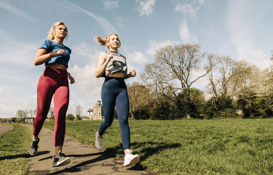 Two girls running in a park in Bristol, UK