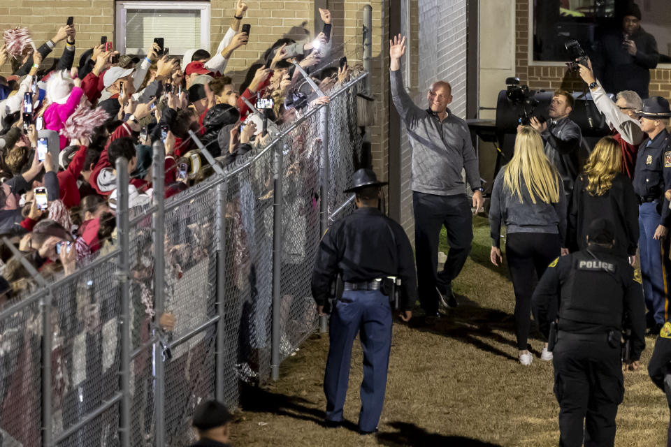 New Alabama football head coach Kalen DeBoer, center top, waves to cheering fans as he arrives at Tuscaloosa National Airport two days after former coach Nick Saban announced his retirement Friday, Jan. 12, 2024, in Tuscaloosa, Ala. (AP Photo/Vasha Hunt)
