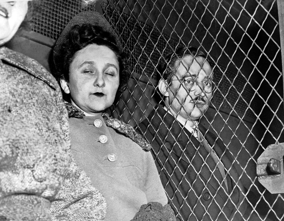 Ethel Rosenberg on one side of a chain-link pen, with her husband, Julius, behind it.