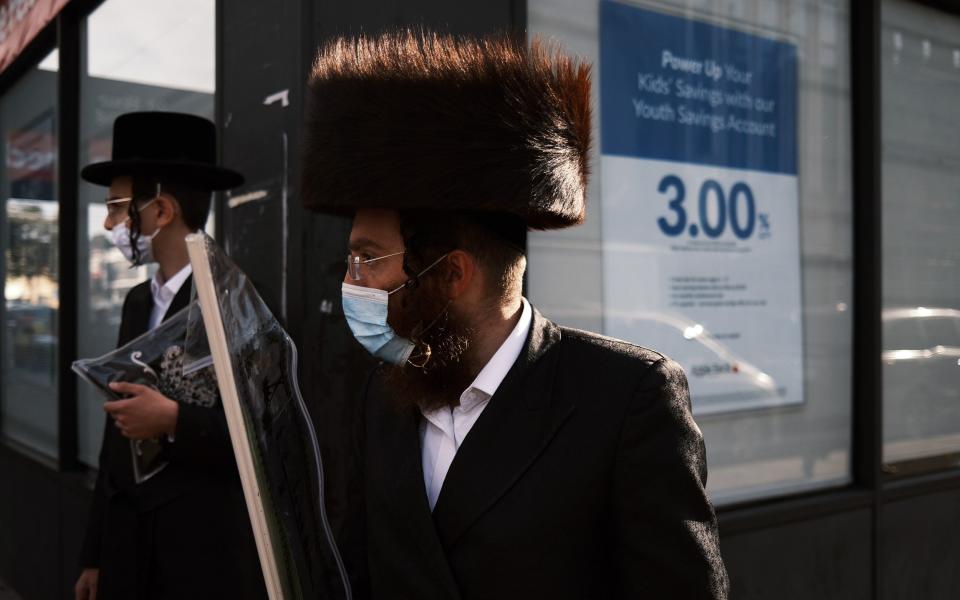 People walk along a street in the Brooklyn neighborhood of Borough Park - Spencer Platt/Getty Images