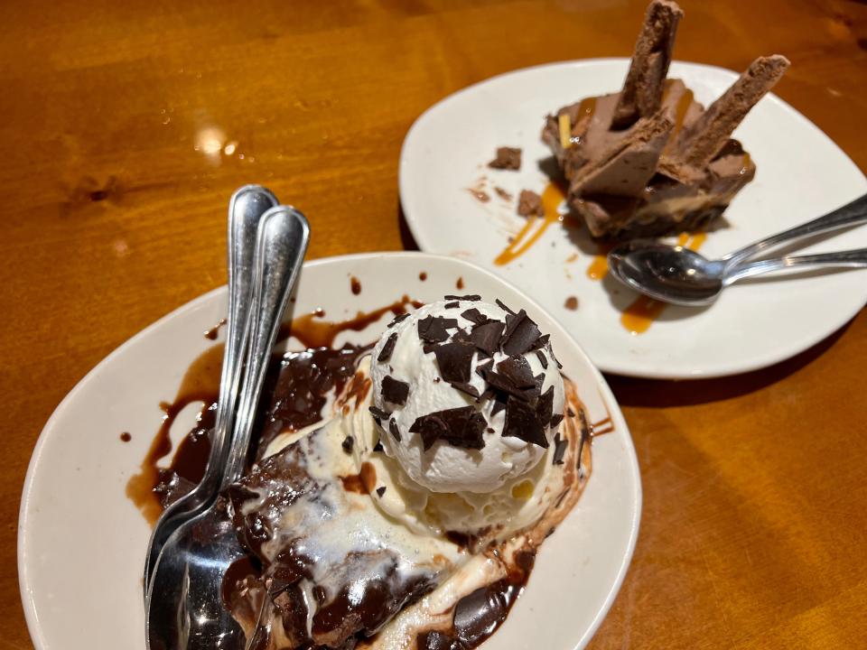 two plates, one with ice cream and chocolate shards and other with a chocolate dessert