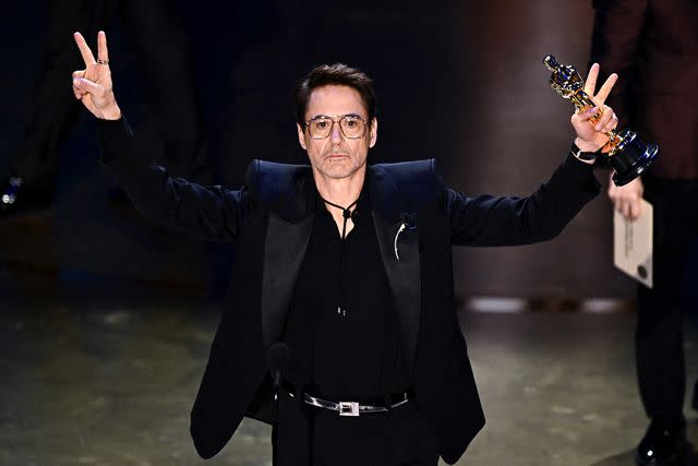 <p>PATRICK T. FALLON/AFP via Getty Images</p> Robert Downey Jr. accepts the award for Best Supporting Actor for "Oppenheimer" at 2024 Oscars