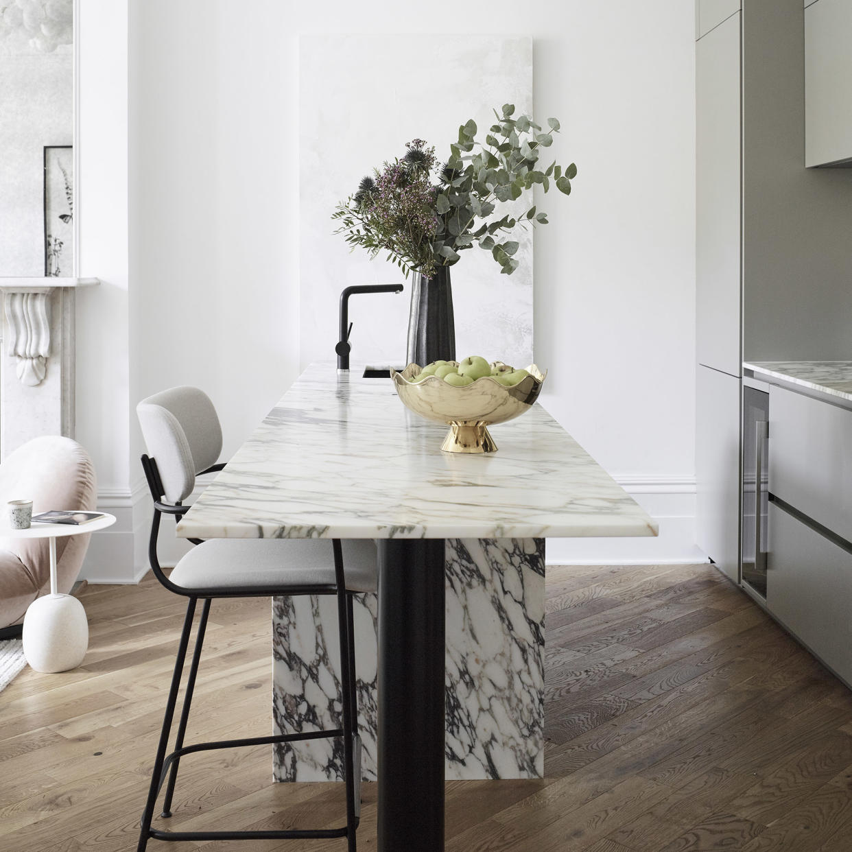  Kitchen with marble table and bouquet of flowers. 