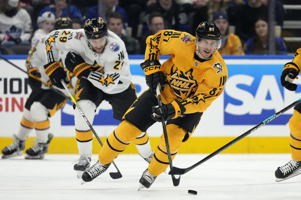 Team MacKinnon forward Sidney Crosby (87), of the Pittsburgh Penguins, skates the puck down ice against Team McDavid during the NHL All-Star Game 3-on-3 hockey tournament in Toronto, Ontario, Saturday, Feb. 3, 2024. (Frank Gunn/The Canadian Press via AP)