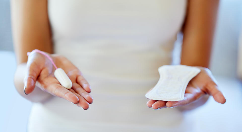 A woman holding pad and tampon