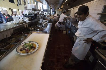 A chef stands next to a Seared Ahi Medallions plate at Kate Mantilini restaurant in Beverly Hills, California June 4, 2014. REUTERS/Mario Anzuoni