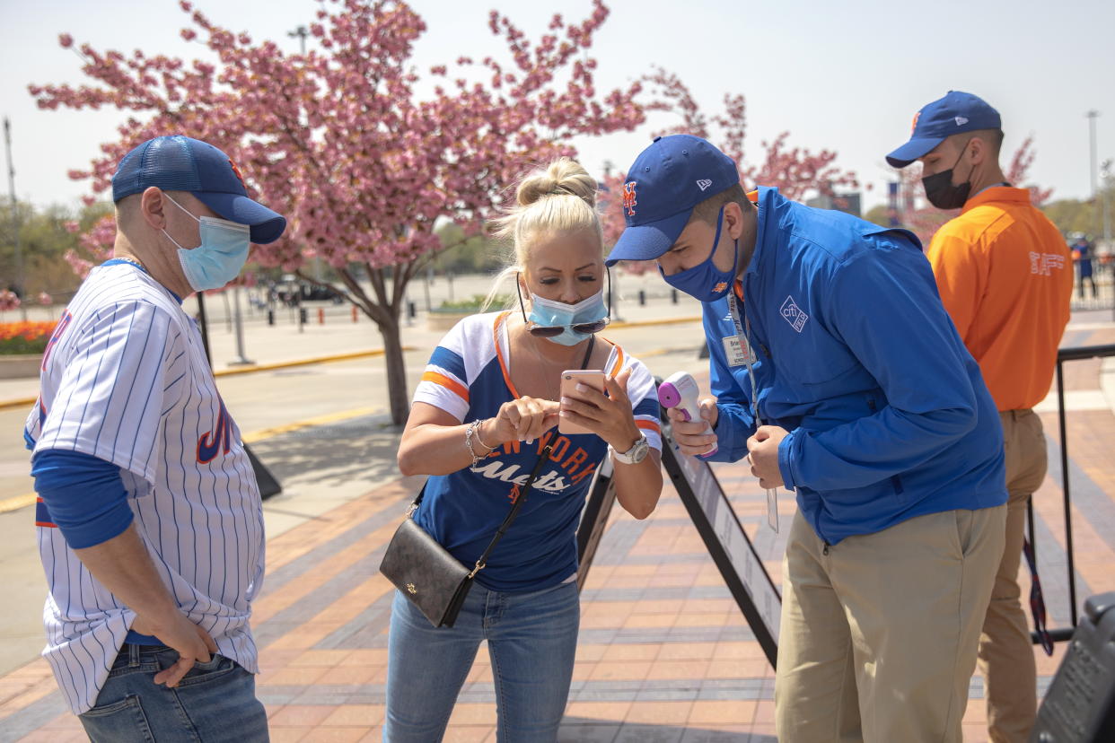 A Mets fan shows a vaccine passport on her phone as she arrives for a game at Citi Field in New York on April 24. (Jeenah Moon/Reuters)