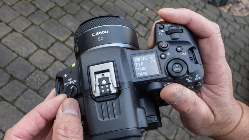 Canon EOS R5 C hybrid video camera held in a man's hands