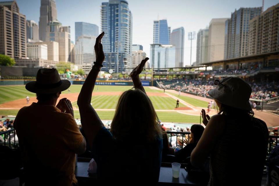 Todd Wiedman, from left, Stacy Wiedman, and Stephanie Wiedman, all of Charlotte, N.C., celebrate a run from the Charlotte Knights during a game against the Memphis Redbirds at Truist Field in Charlotte, N.C., Sunday, April 17, 2022.