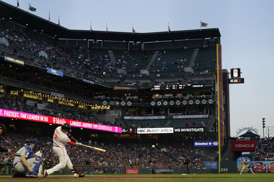 San Francisco Giants' Buster Posey hits an RBI single in front of Los Angeles Dodgers catcher Will Smith during the sixth inning of a baseball game in San Francisco, Tuesday, July 27, 2021. (AP Photo/Jeff Chiu)