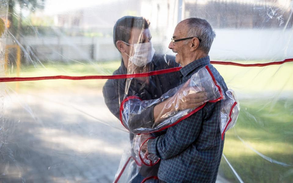 A son hugs his father at the Geriatric Clinic in Gravatai, Brazil - Lucas Uebel/Getty Images South America