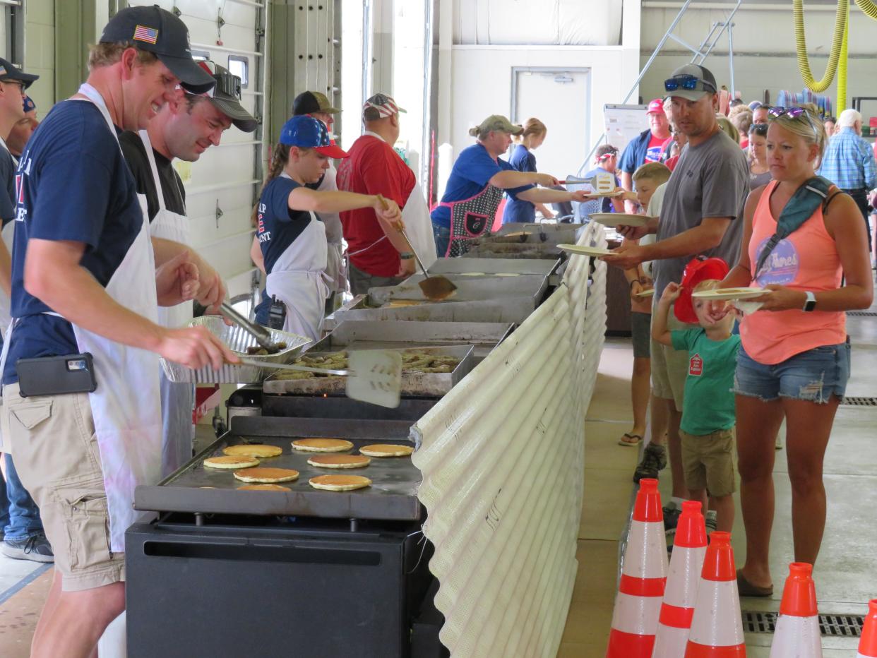 Members of the Graafschap Fire Department serve up breakfast to hundreds of people on Monday, July 4, at the annual pancake breakfast at the fire station, 4534 60th St., Holland.