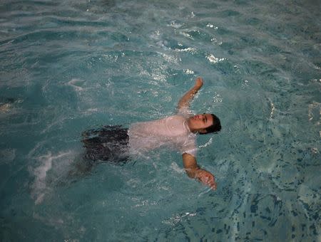 Raul Contreras, 19, of Honduras, who is seeking refugee status in Canada, works out at the pool of a long-stay hotel in Toronto, Ontario, Canada April 9, 2017. REUTERS/Chris Helgren