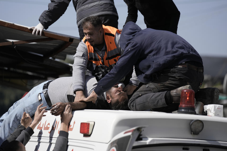 An injured Palestinian is lifted onto an ambulance during clashes with Israeli forces in the West Bank city of Nablus, Wednesday, Feb. 22, 2023. Israeli troops moved into the city, setting off fighting that killed several Palestinians, including a 72-year-old man, Palestinian health officials said. The Israeli military gave few details about its operation in the northern city, which is known as a militant stronghold, and the army frequently operates there. (AP Photo/Majdi Mohammed)