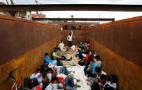 Migrant workers and their families board a truck to return to their villages during a 21-day nationwide lockdown to limit the spreading of coronavirus disease (COVID-19), in Simbhaoli