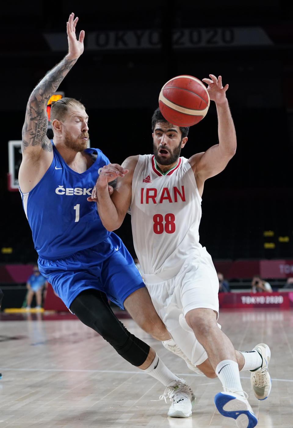 Iran's Behnam Yakhchalidehkordi (88) carries the ball past Czech Republic's Patrik Auda during men's basketball game at the 2020 Summer Olympics, Sunday, July 25, 2021, in Saitama, Japan. (AP Photo/Charlie Neibergall)