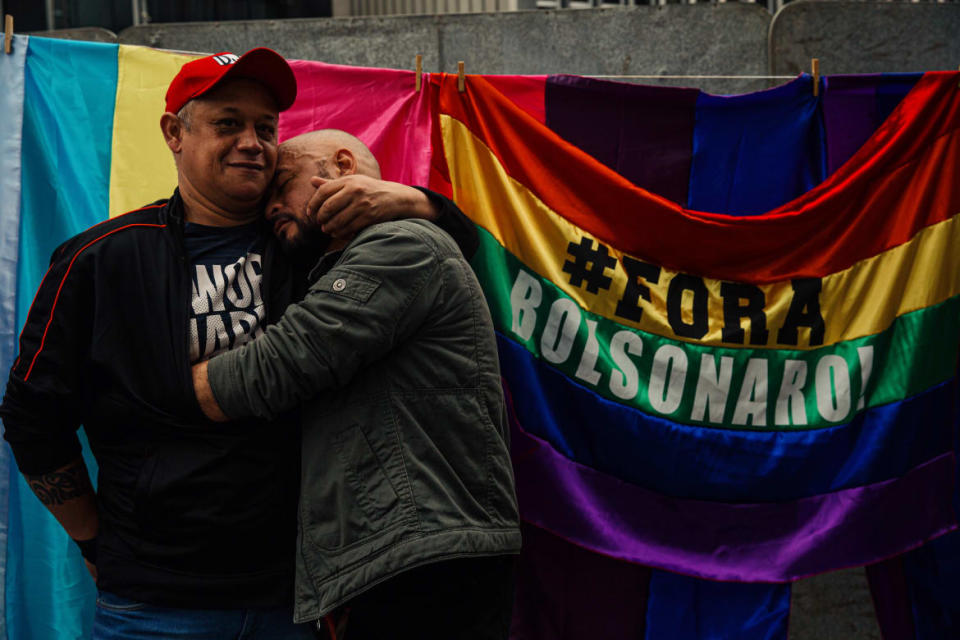 <div class="inline-image__caption"><p>A gay couple hugs near a sign that reads "Bolsonaro out" during the 26th Sao Paulo Gay Pride Parade on June 19, 2022, in Sao Paulo, Brazil. </p></div> <div class="inline-image__credit">Luca Meola/Getty</div>