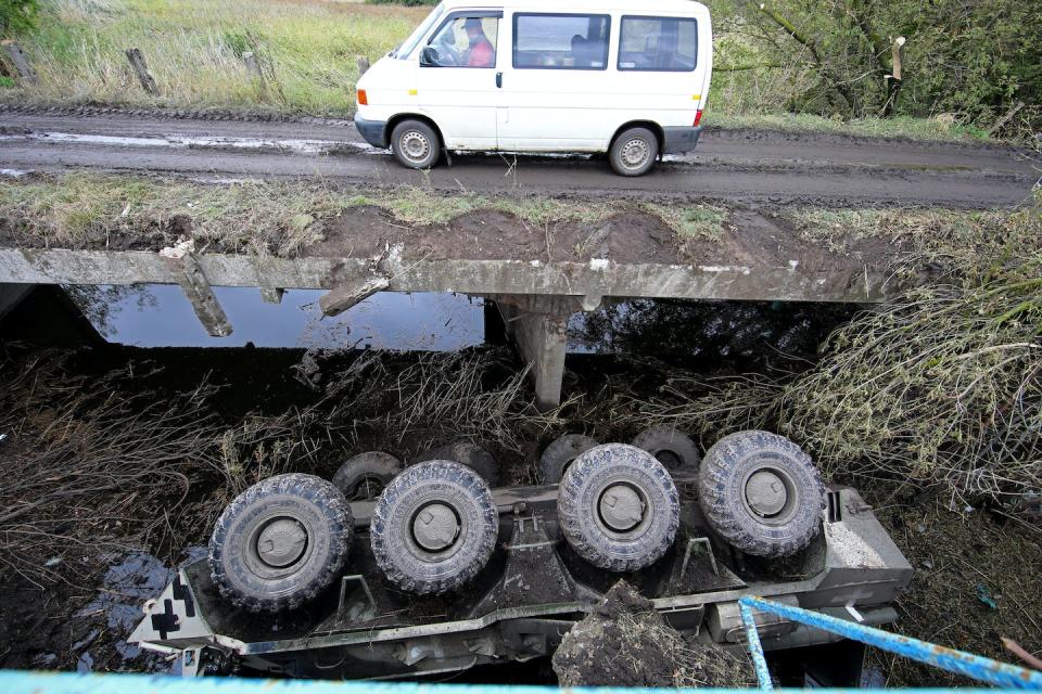 A van drives over a bridge, past a destroyed Russian military vehicle in the Kharkiv region of northeastern Ukraine on Sept. 13, 2022. <a href="https://media.gettyimages.com/photos/van-moves-along-a-bridge-as-a-destroyed-russian-military-vehicle-is-picture-id1243215099" rel="nofollow noopener" target="_blank" data-ylk="slk:Vyacheslav Madiyevskyy/ Ukrinform/Future Publishing via Getty Images;elm:context_link;itc:0;sec:content-canvas" class="link ">Vyacheslav Madiyevskyy/ Ukrinform/Future Publishing via Getty Images</a>
