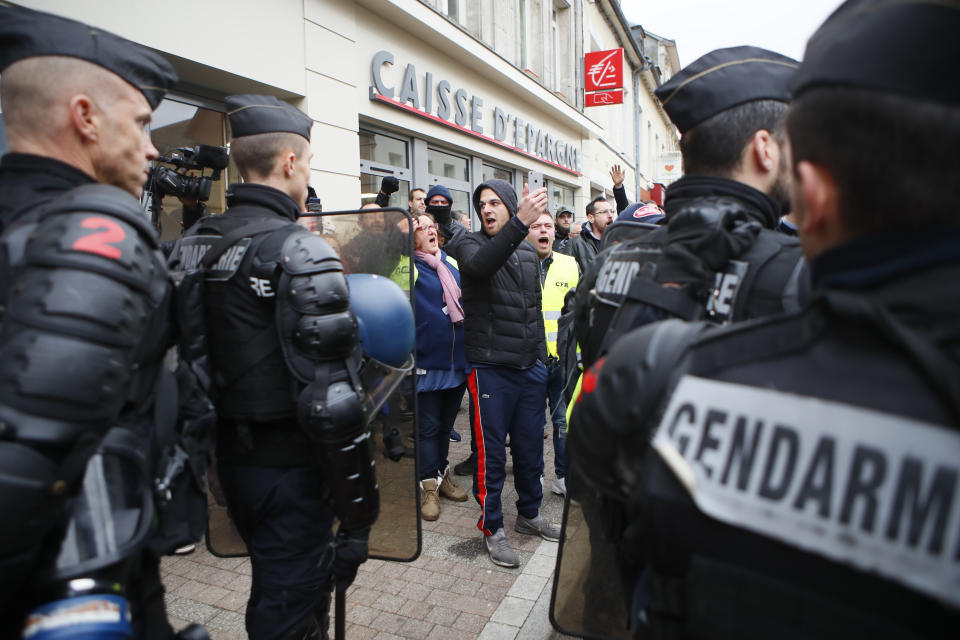 A demonstrator argues with riot police officers before French President Emmanuel Macron's visit in Grand Bourgtheroulde, Normandy, Tuesday, Jan.15, 2019. Macron is formally launching a "grand debate" to try to appease the yellow vest movement following weeks of anti-government protests. (AP Photo/Francois Mori)