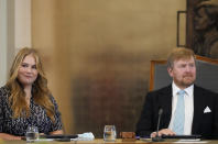 Heir to the Dutch throne Princess Amalia, left, takes an honorary seat at the Council of State, the highest government advisory body in The Hague, Netherlands, Wednesday, Dec. 8, 2021, as her father King Willem-Alexander, right, looks on, one day after celebrating her eighteenth birthday. (AP Photo/Peter Dejong, Pool)